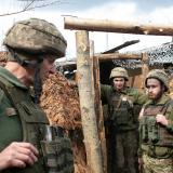 One female and three male Ukrainian soldiers stand in a trench on the front lines of the war in Donbas.