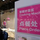 Facility staff observes a lunch delivered by a robotic cooking machine which cooked the meal at the dining hall at the Main Press Centre ahead of the Beijing 2022 Winter Olympics