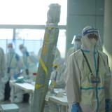 Staff members wearing personal protective equipment (PPE) designed to prevent the spread of the coronavirus disease (COVID-19), wait for passengers at Beijing Capital International Airport ahead of the Beijing 2022 Winter Olympics, in Beijing, China, January 31, 2022.