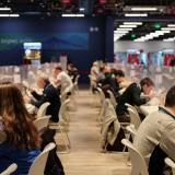 People eat between plastic barriers at the dining hall of the main media center at Beijing 2022 Winter Olympics in Beijing