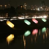 plastic bottles, illuminated by colorful lights, are photographed along the tiete river in brazil at night