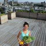 Sibylle, a biotechnology engineering student, poses with Orgeval yellow courgettes, chives, parsley, broad beans, and spring onions from the vegetable kitchen garden installed on the roof of the Maison de la Mutualité building in Paris, on July 23, 2013