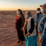 Native American family watching the sunset wearing masks for protection from COVID-19, at Monument Valley Tribal Park, Utah.