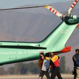 Workers carry a batch of the Pfizer-BioNTech COVID-19 vaccine to a helicopter.