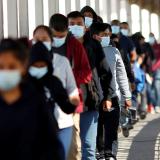 Migrants expelled from the U.S. and sent back to Mexico under Title 42, walk towards Mexico at the Paso del Norte International border bridge.