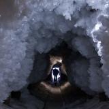 A man walks through a tunnel in permafrost covered with ice crystals