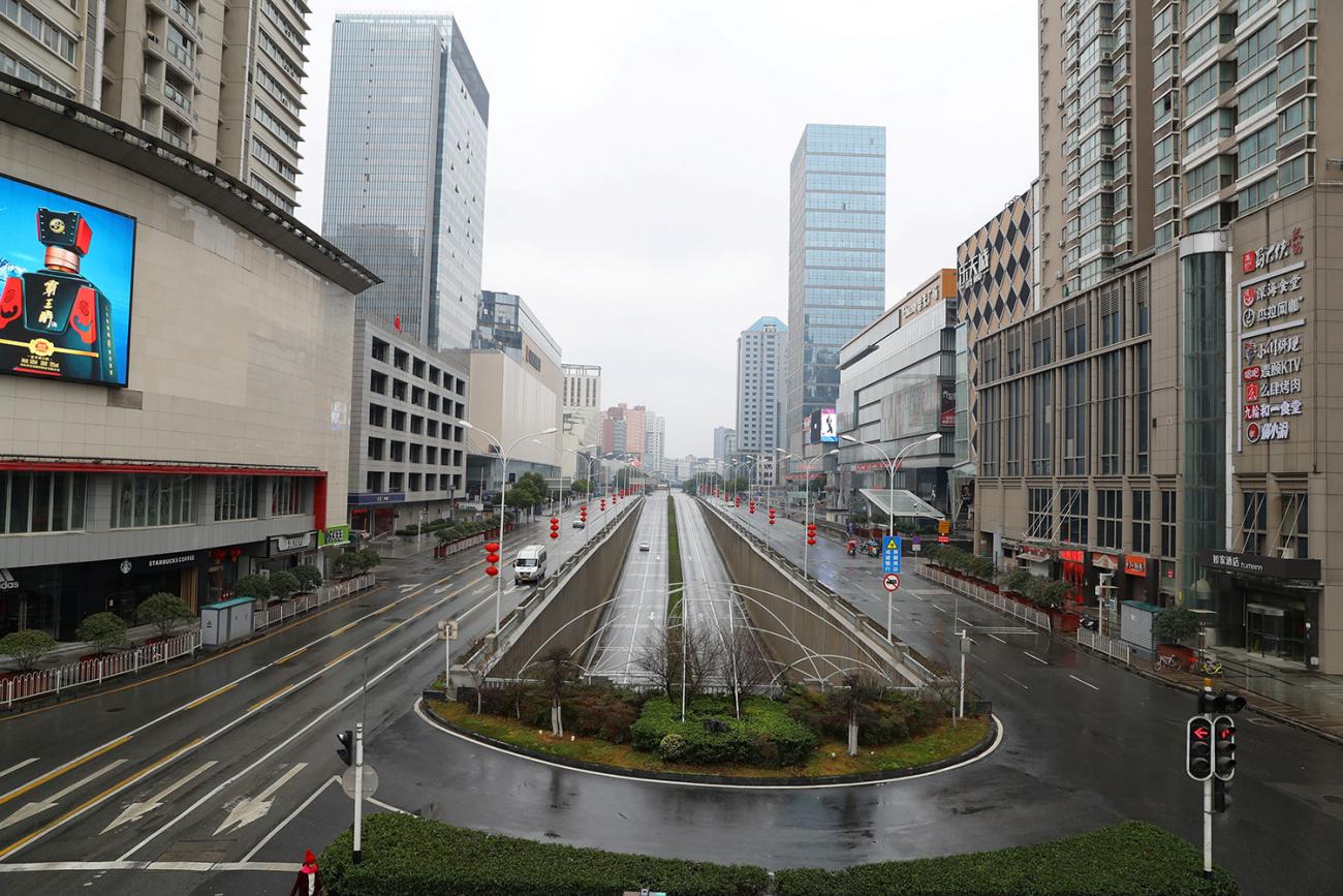 Picture shows a wide avenue seen from a high vantage with almost completely empty streets.
