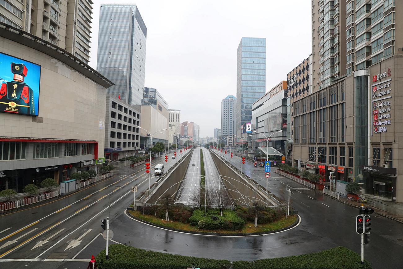 Picture shows a wide avenue seen from a high vantage with almost completely empty streets. 