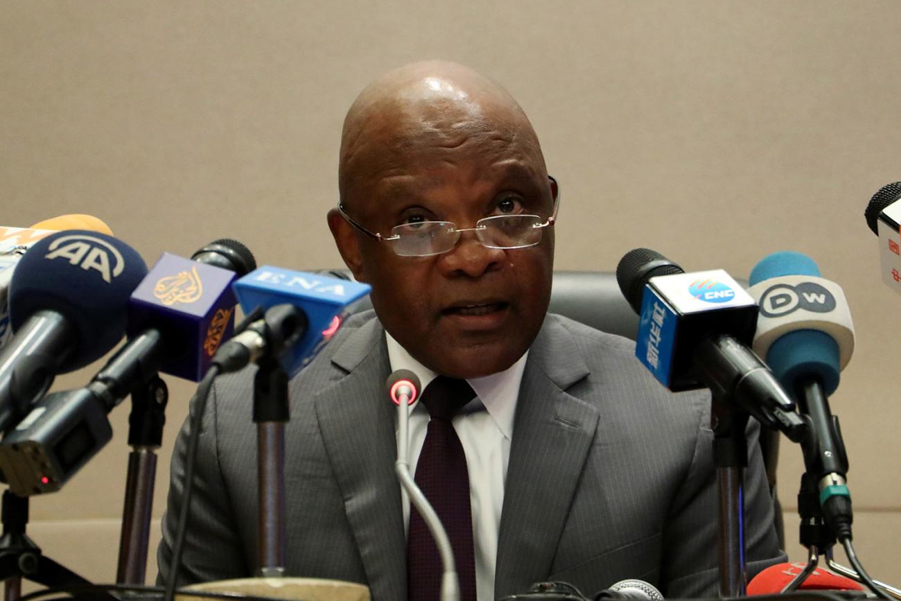 Photo shows the African CDC director speaking in front of a bank of microphones at a press conference. 