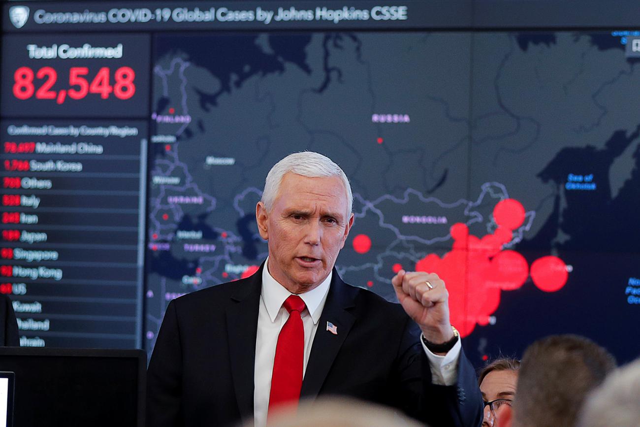 The picture shows Pence standing in front of a huge screen with situation data on it. 