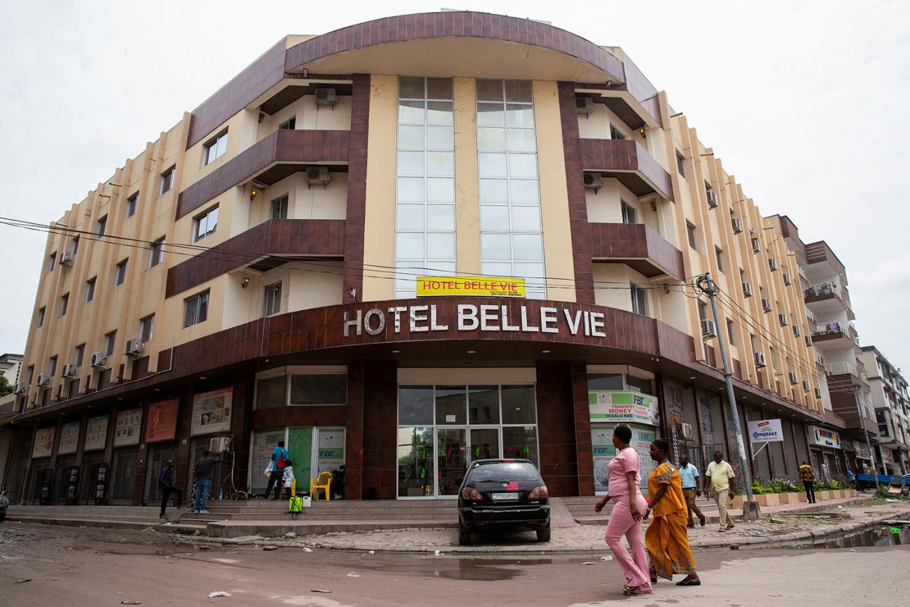 The image shows two women walking past the entrance of the hotel.