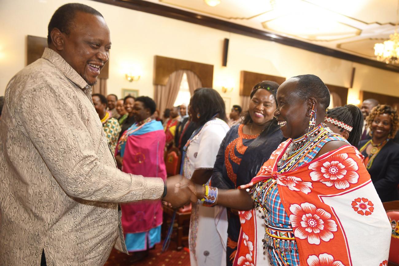 The photo shows the president shaking hands with several women. 