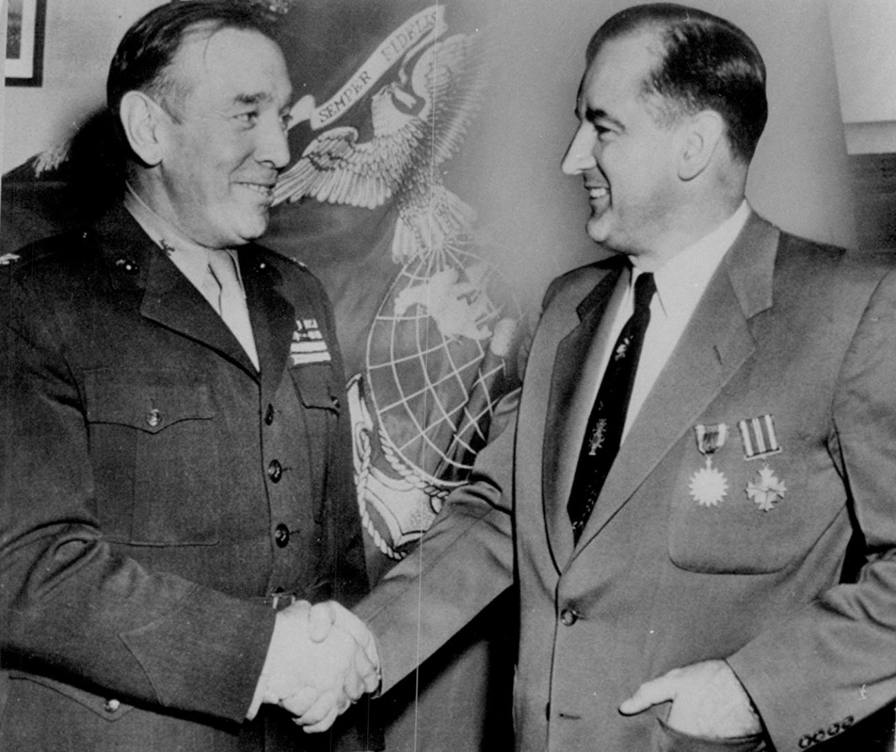 Historic photo shows McCarthy shaking hands with a uniformed officer. 