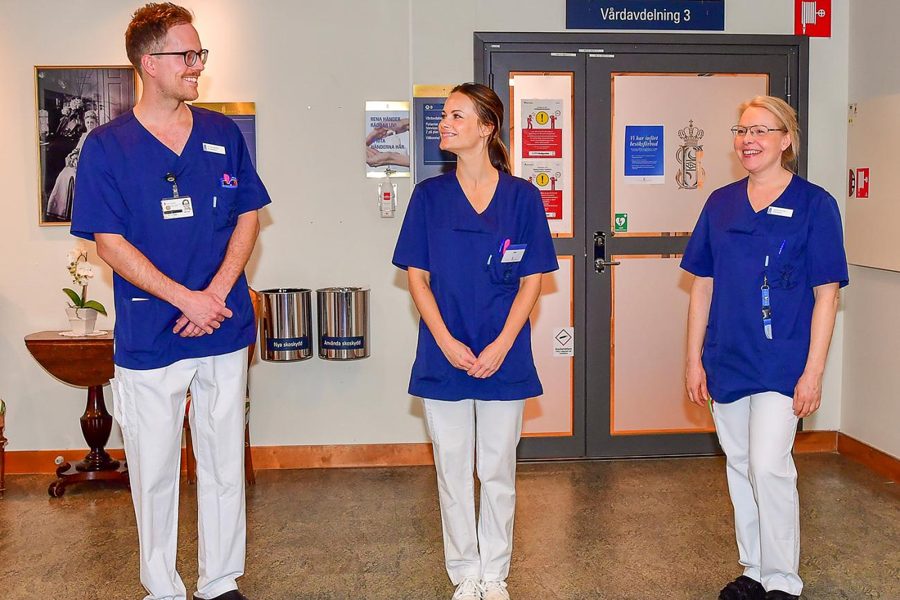 The picture shows the princess in a nurse's uniform standing between the two actual nurses in this posed photo. All three are smiling and seem jovial. Picture taken April 16, 2020. 