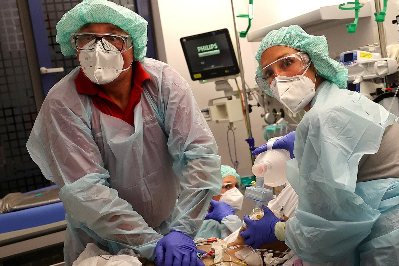 The photo shows two doctors with a patient. They appear to be doing CPR.