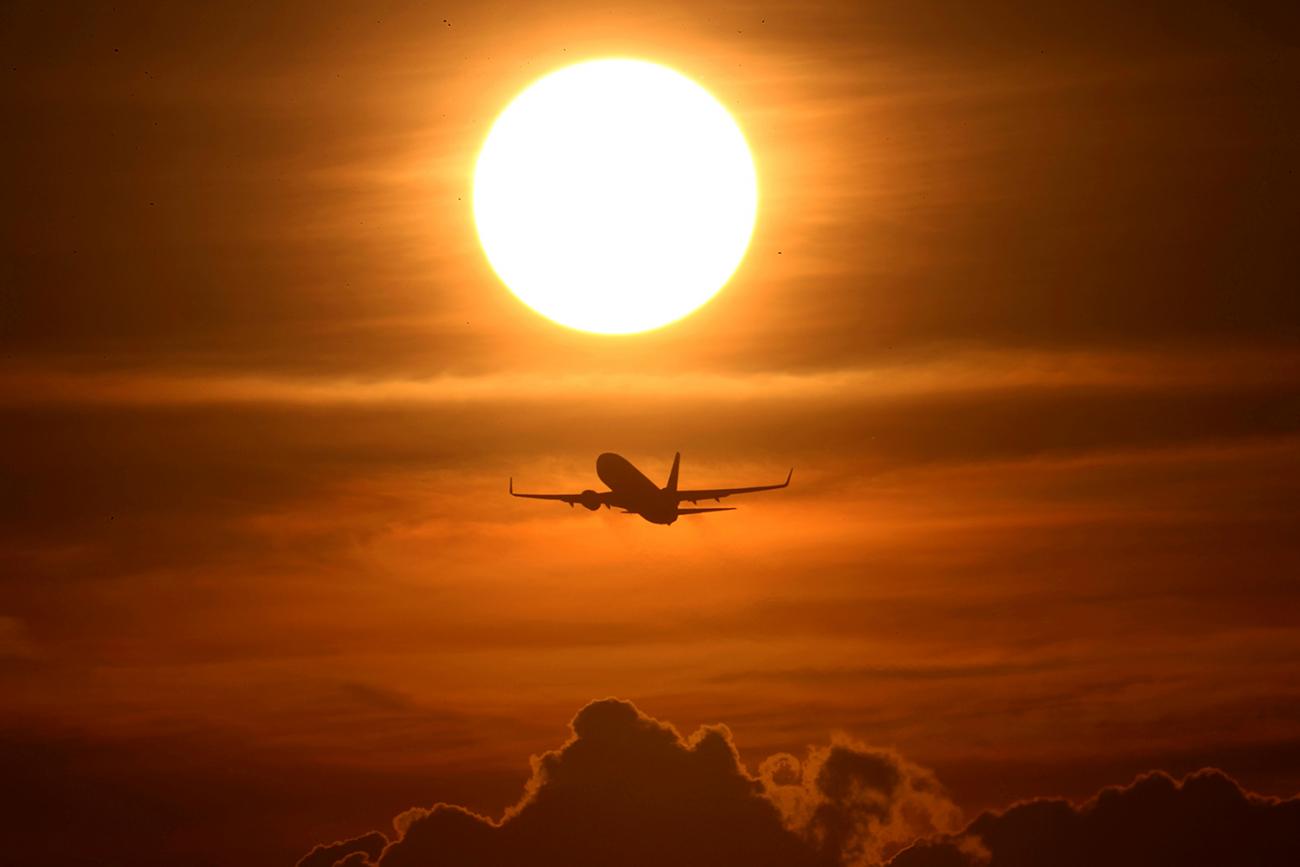  The photo shows a plane flying into the sunset. 