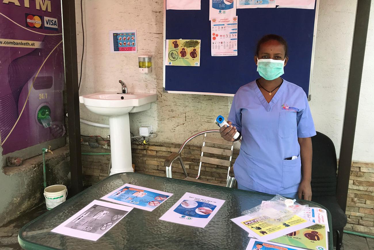 The photo shows a health worker at a table. 