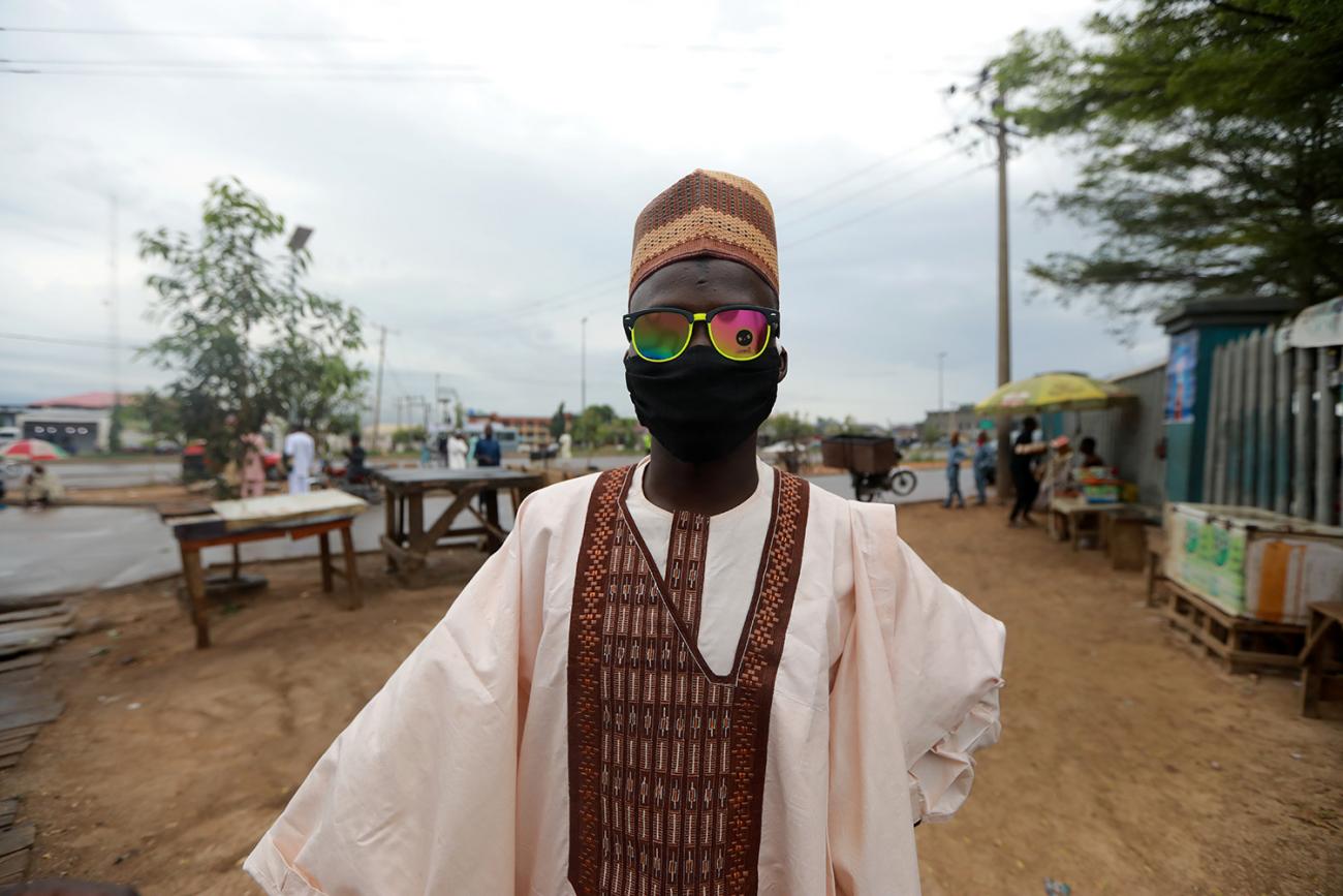This is a striking image with a man whose face is covered by a mask as well as colorful sunglasses.