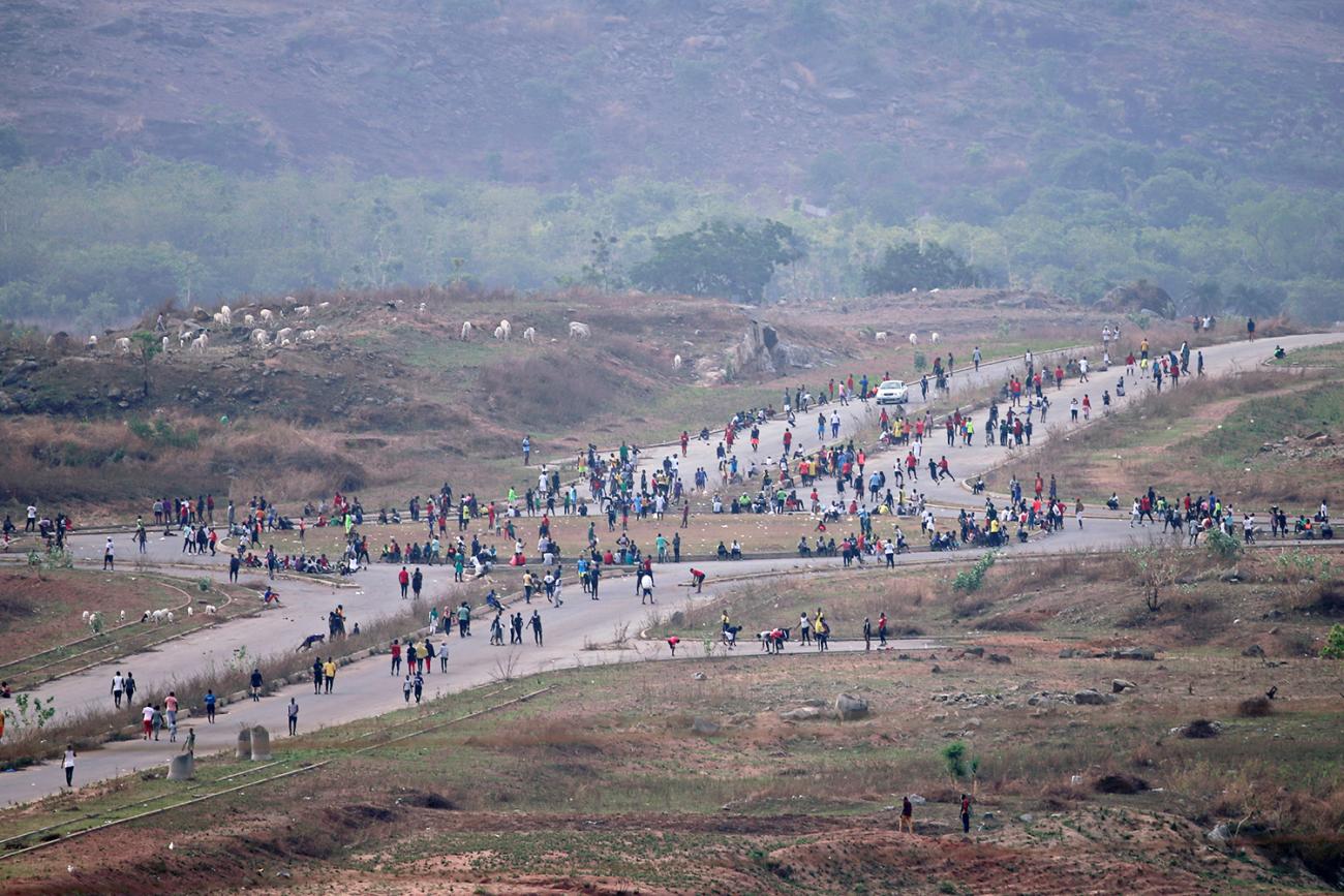 The photo shows a crisscrossed country road from a great distance with an immense crowd of people moving through the crossroads. 