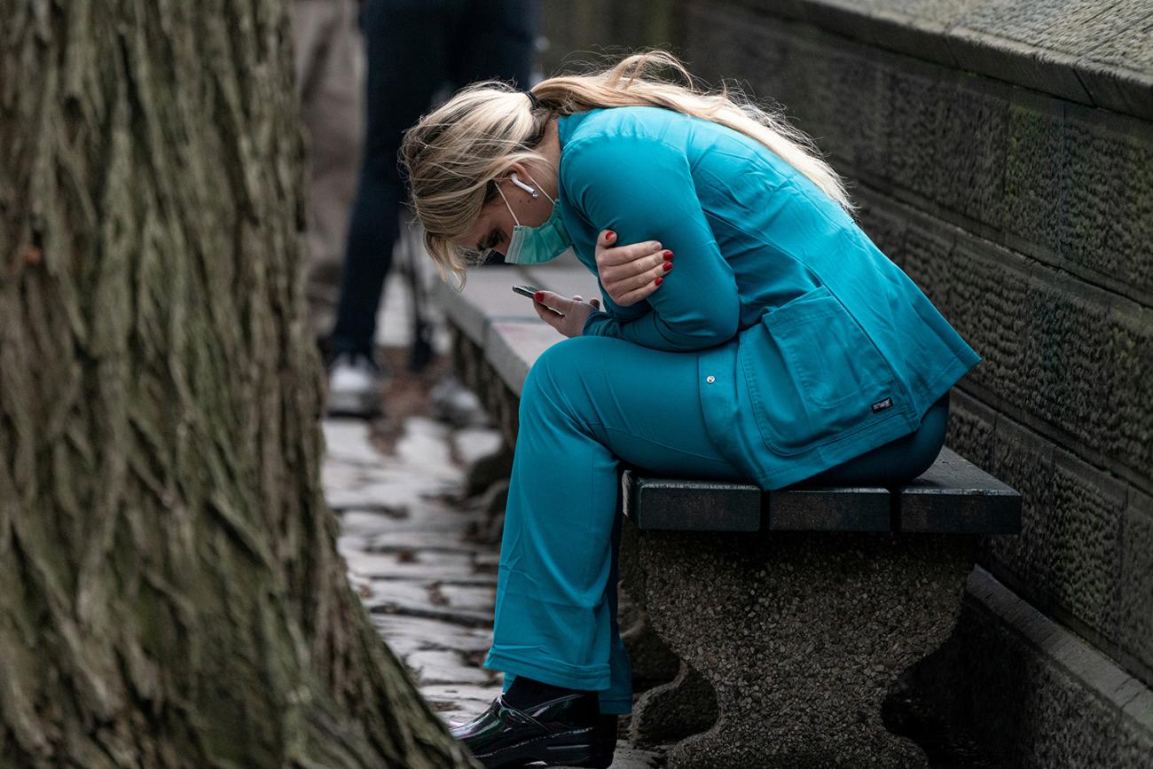 The photo shows a nurse sitting on a bench doubled over. Is she in pain? Emotionally distraught? Just plain tired? The viewer cannot tell. 