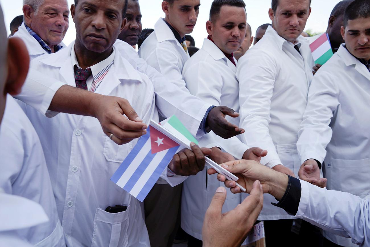 The photo shows doctors lined up taking flags of Italy and Cuba. 