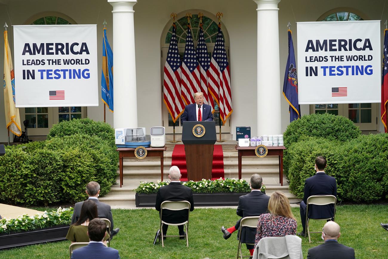 The photo shows the president at a podium with huge signs hung behind him that read, "America leads the world in testing." 
