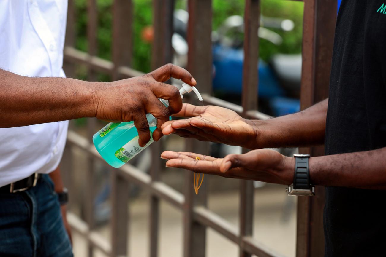 Picture shows a pair of hands outstretched and receiving a splash of alcohol soap. 