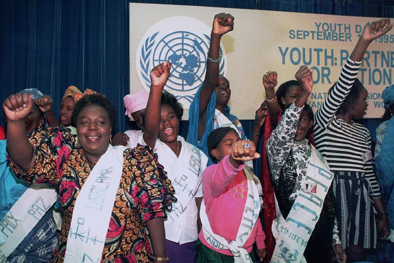 The photo shows the UN official surrounded by singers, all holding a fist in the air. 