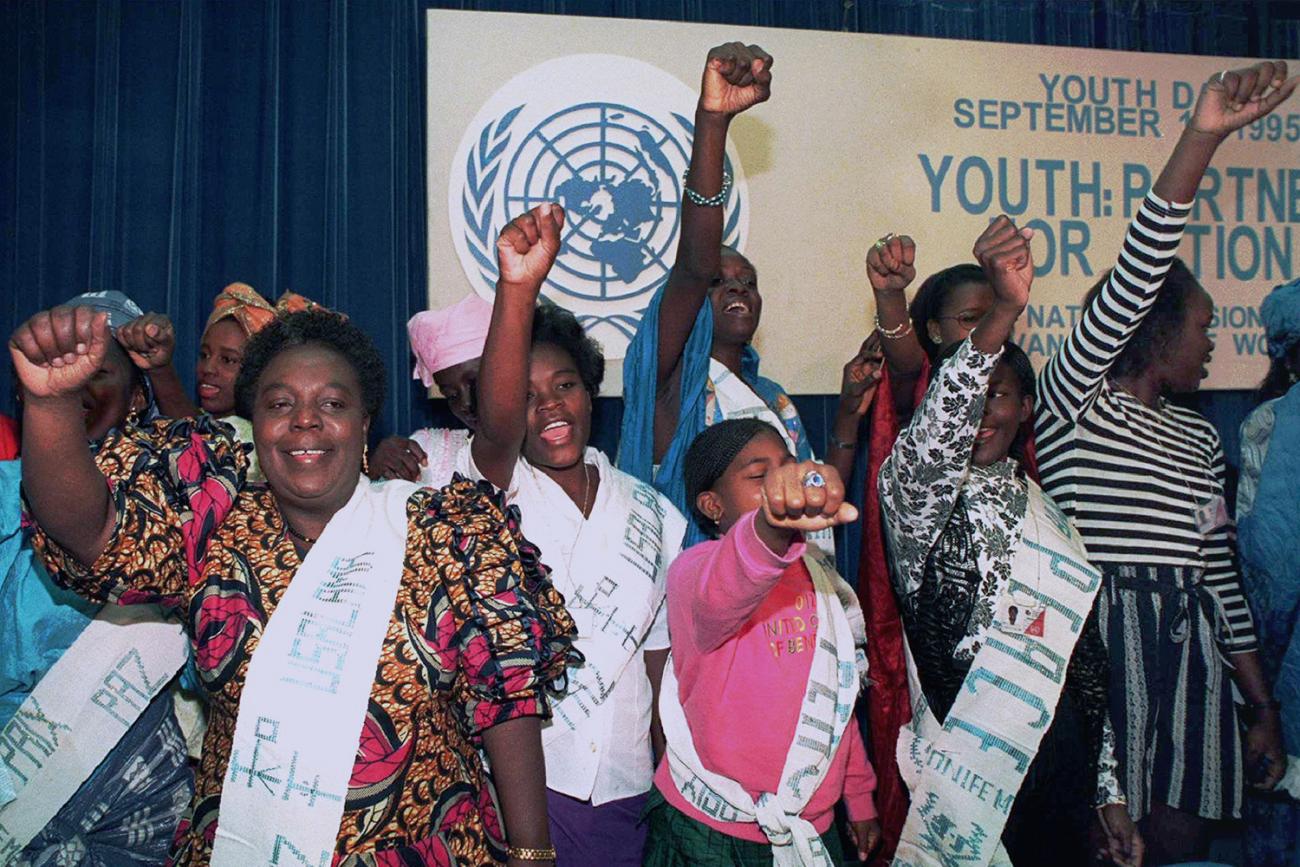 The photo shows the UN official surrounded by singers, all holding a fist in the air.