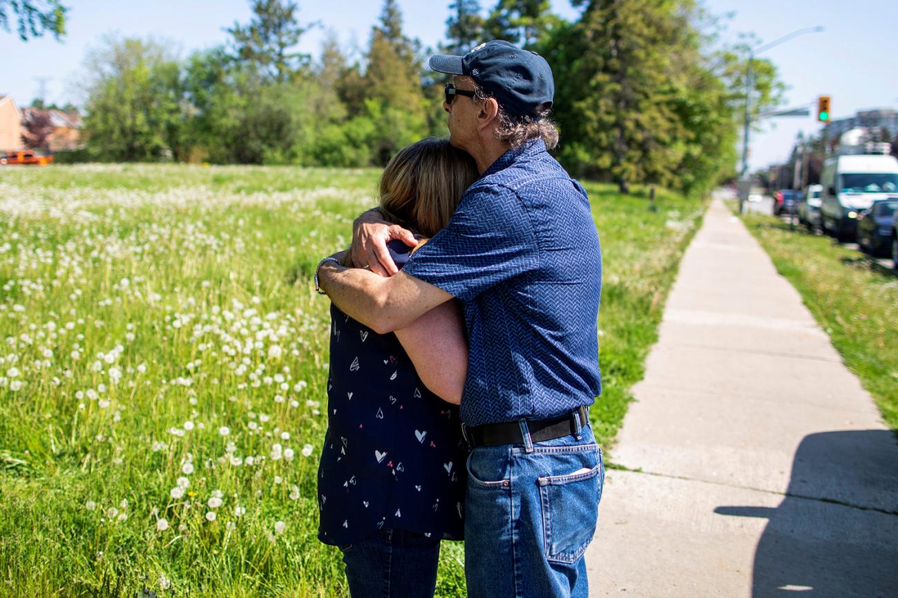 The photo shows a wife and husband in a solemn embrace. 