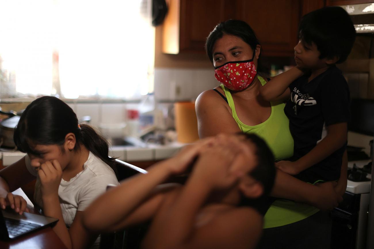 The photo shows the two students sitting around a kitchen table. Alexander appears to be throwing back his head in frustration. 