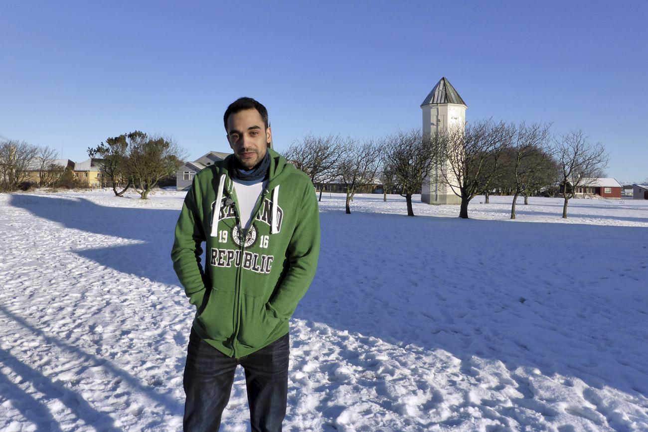 The photo shows a man outside in a snowy field. 