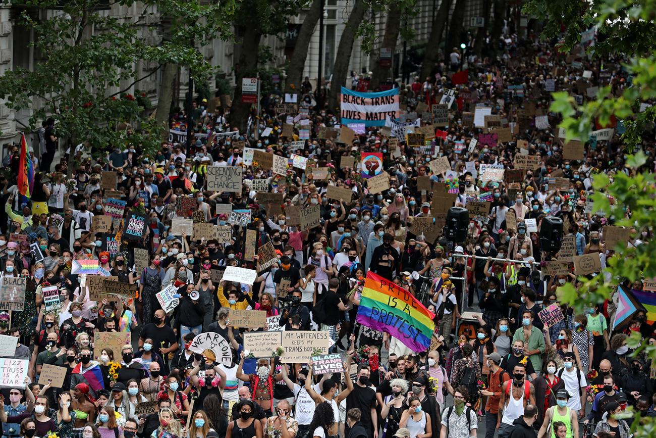 The photo shows a massive demonstration from high above with people walking through the streets of London carrying signs. 