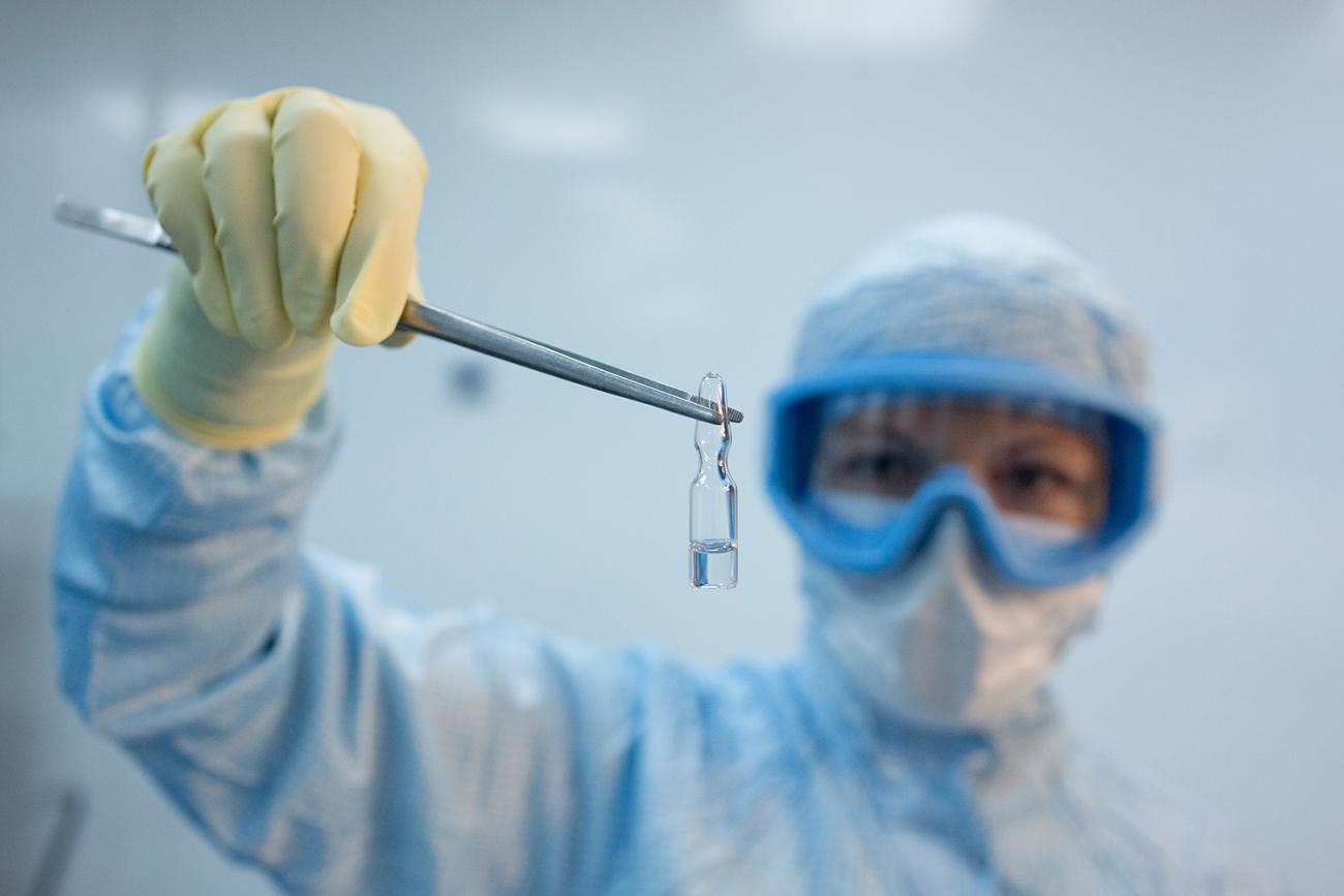 Picture shows a laboratory worker holding the vaccine up to the camera. 