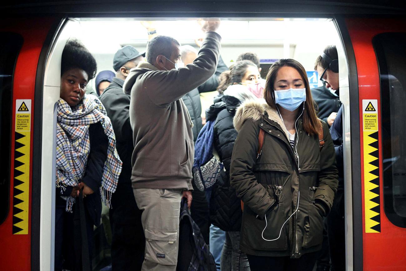 The photo shows the open door of the subway train crowded with commuters, some of whom are not wearing masks. 