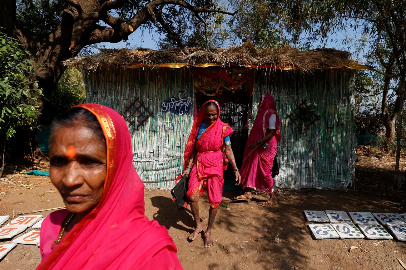 The photo shows several older women leaving a small class building. 