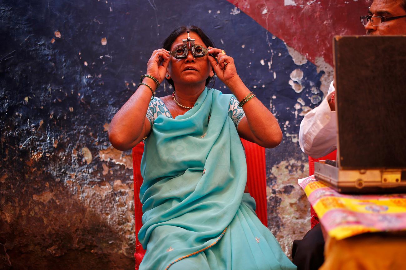 The photo shows a woman wearing examination lenses as her vision is being checked. 