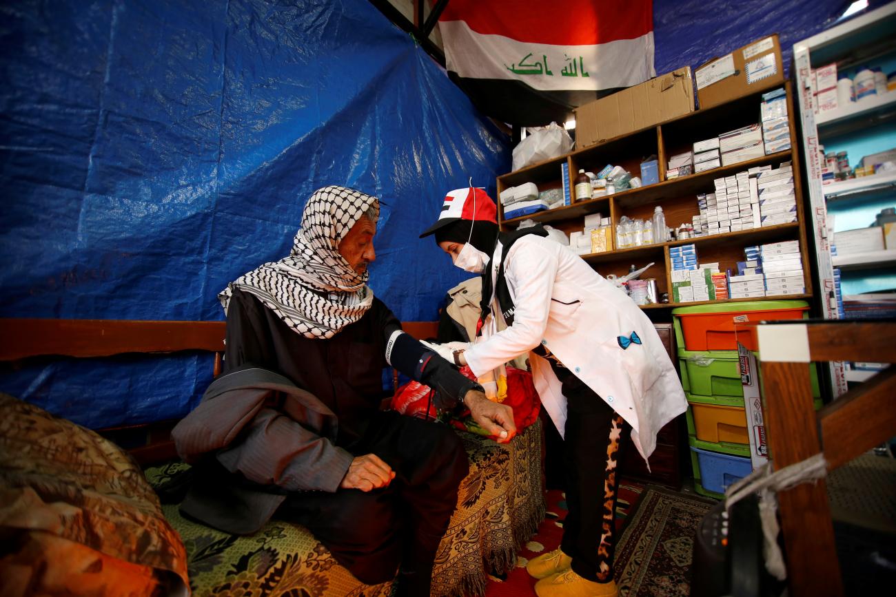 A young Iraqi nurse checks a man's blood pressure in Baghdad, Iraq on December 17, 2019.