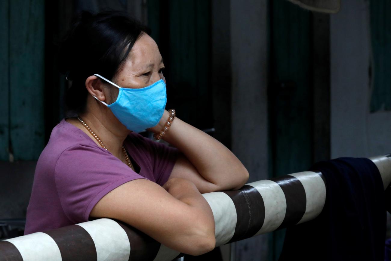A middle-aged Vietnamese woman wearing a blue protective mask is seen inside a quarantined hamlet with a house of a coronavirus disease (COVID-19) patient in Hanoi, Vietnam August 4, 2020. 