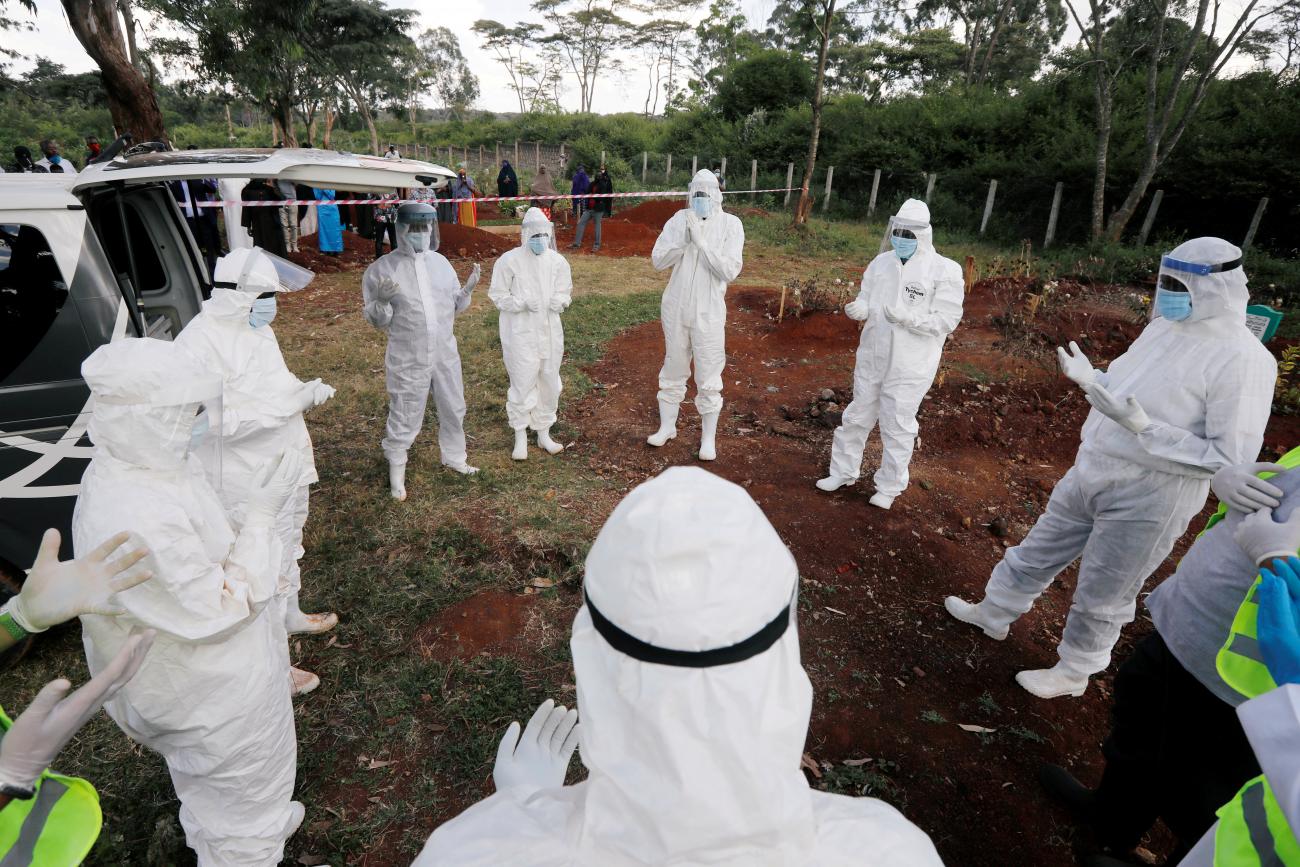Volunteers from the National Muslim COVID-19 Response Committee, wearing Personal Protective Equipment (PPE), pray before the burial of Abdullahi Adan, 52, who died due to the coronavirus disease (COVID-19), at the separated section of the muslim cemetery in Nairobi, Kenya August 6, 2020.