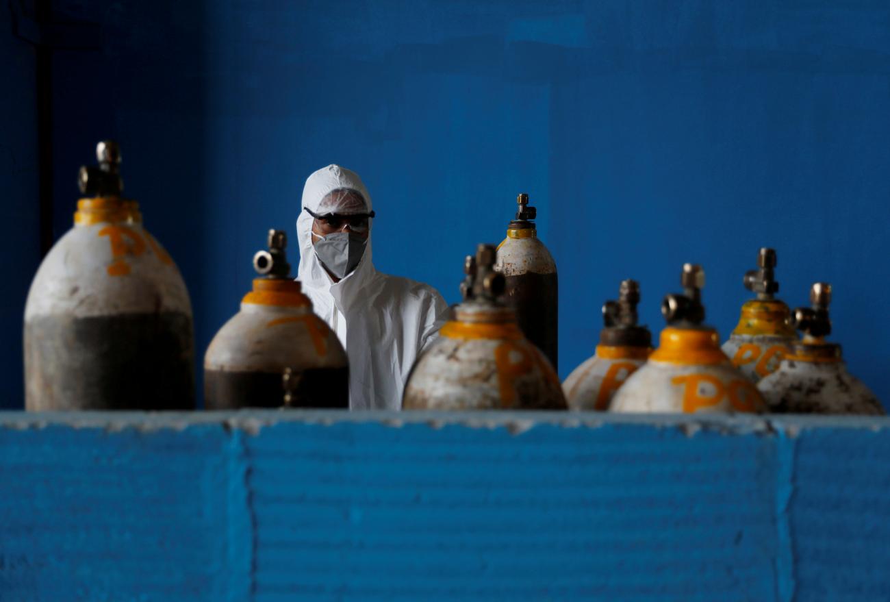 A medical worker stands next to an oxygen cylinder at the Yatharth Hospital in Noida, on the outskirts of New Delhi, India on September 15, 2020. 