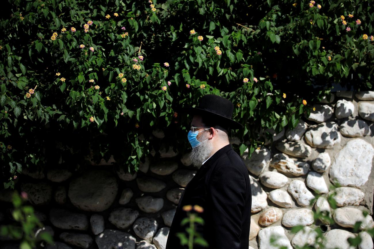 An ultra-Orthodox Jewish man wearing a protective face mask walks outdoors as Israel is set to tighten its second nationwide coronavirus disease lockdown amid a rise in infections, in Ashdod, Israel September 24, 2020. 