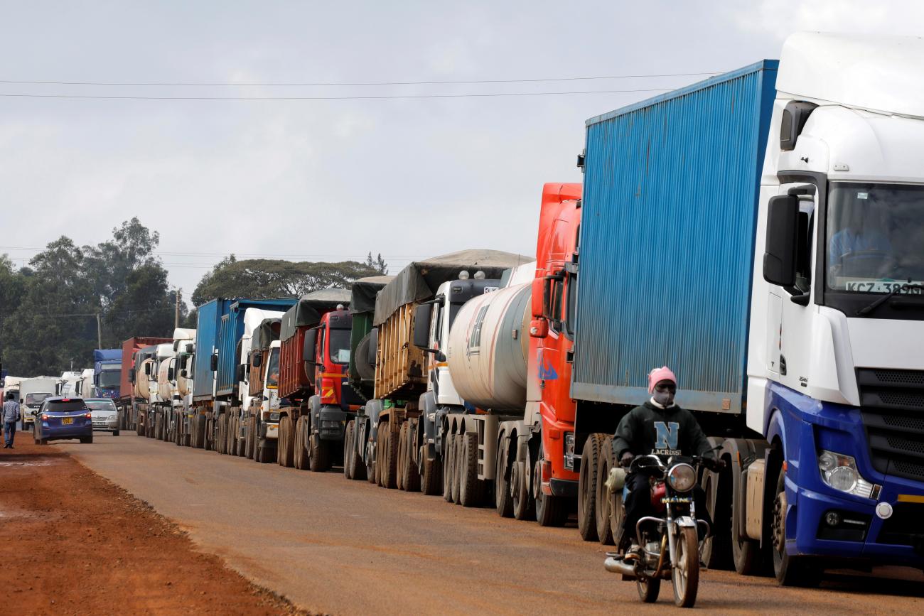 A motorcycle rider drives past a ten kilometer-long line of trucks, trying to cross the Kenyan-Ugandan border from the town of Busia, Kenya on November 14, 2020.