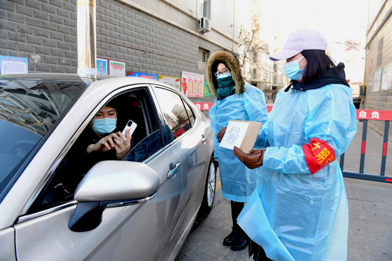 A resident scans a QR code held by a volunteer at the gate of a residential compound in Xinle, following a recent outbreak of the coronavirus disease in Shijiazhuang, Hebei province, China January 9, 2021. 