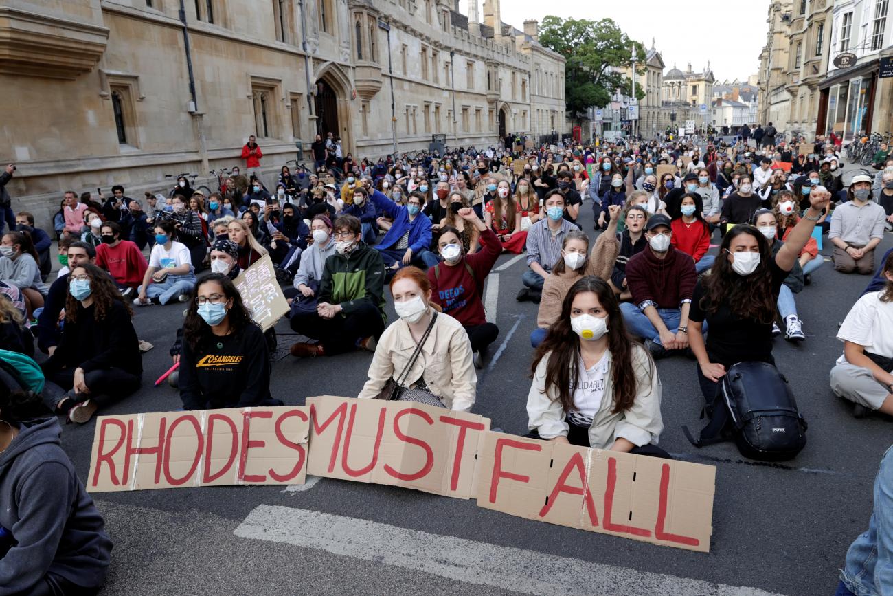 Demonstrators hold placards during a protest for the removal of a statue of British imperialist Cecil Rhodes on the outside of Oriel College in Oxford, United Kingdom on June 9, 2020.