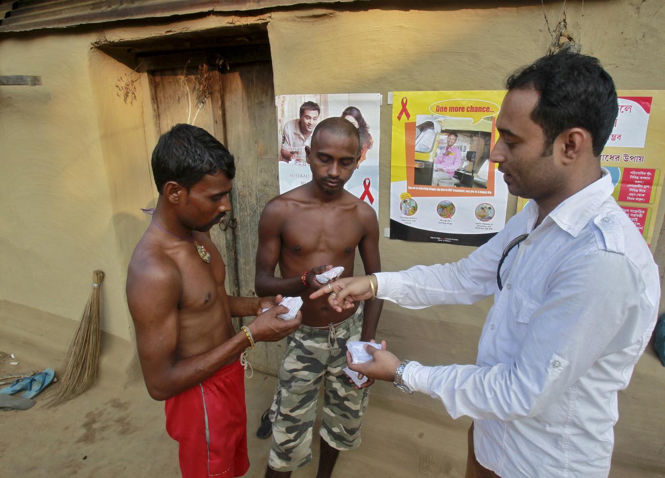 A volunteer distributes free condoms to villagers during an AIDS awareness campaign on the outskirts of Agartala, India on November 6, 2015. 