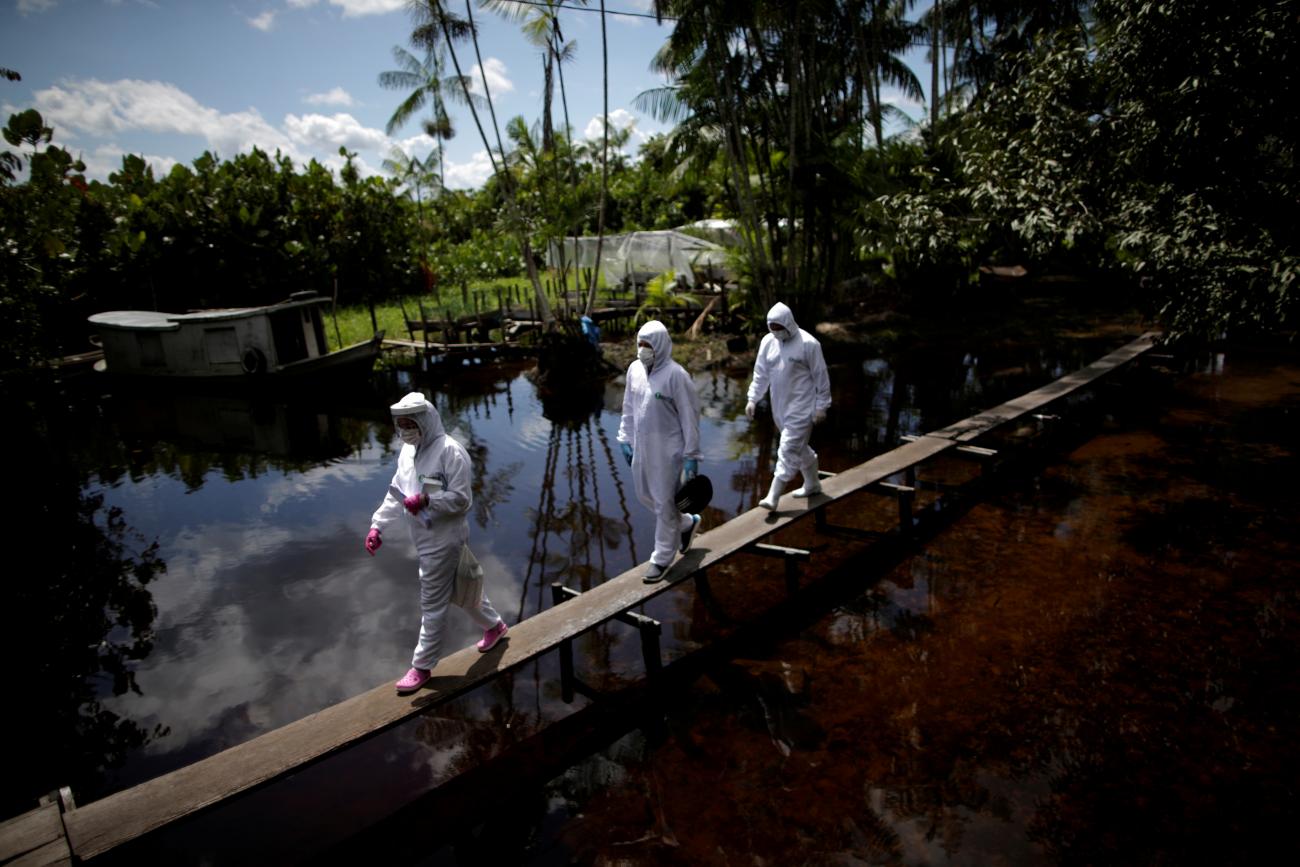 Nurses walk along a bridge to access a house in the riverside community Pinheiro, as they visit riverside communities to check on residents during the coronavirus disease (COVID-19) outbreak, in the municipality of Portel, on Marajo island, Para state, Brazil, June 6, 2020.