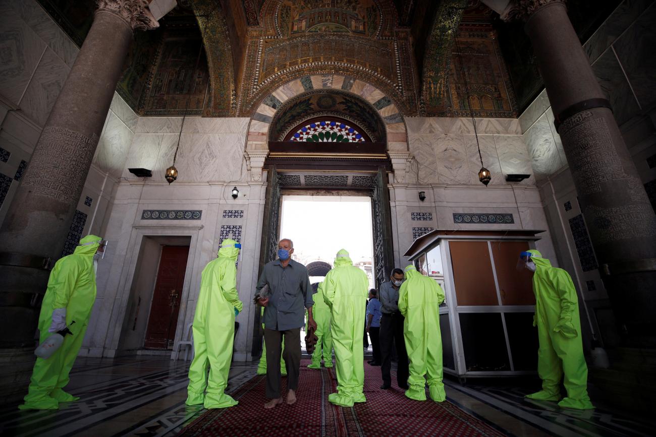 Workers sanitize people attending Friday prayers, after the Syrian government has eased the restrictions amid concerns over the coronavirus disease outbreak, at Umayyad mosque in Damascus, Syria on May 8, 2020.