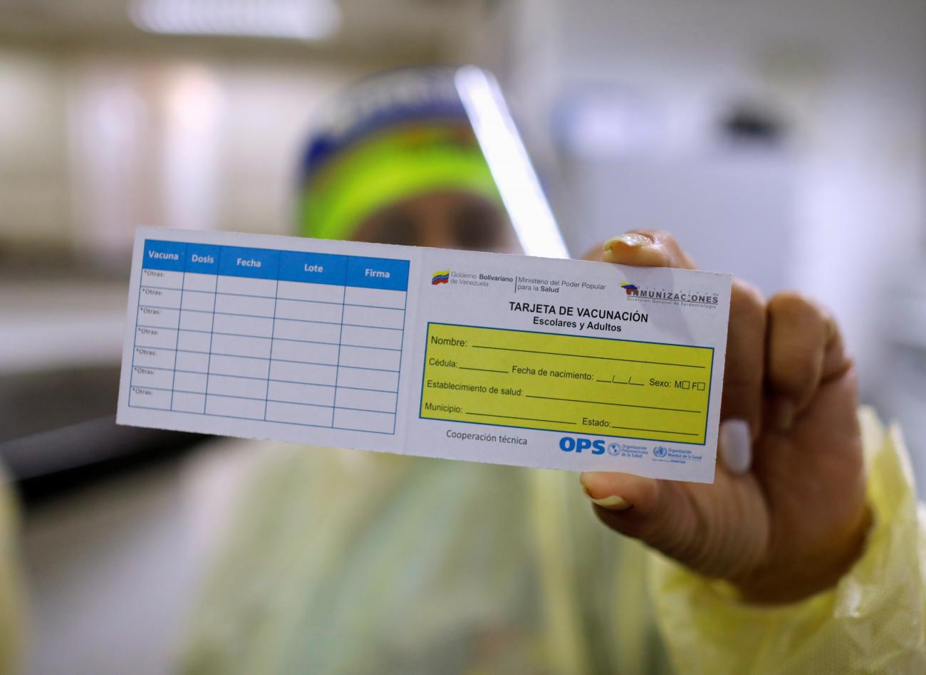 A Venezuelan health worker shows a vaccination card for school children and adults as health workers are being vaccinated with Russia's Sputnik V vaccine against the coronavirus disease (COVID-19, at a hospital, in Caracas, Venezuela February 22, 2021. 