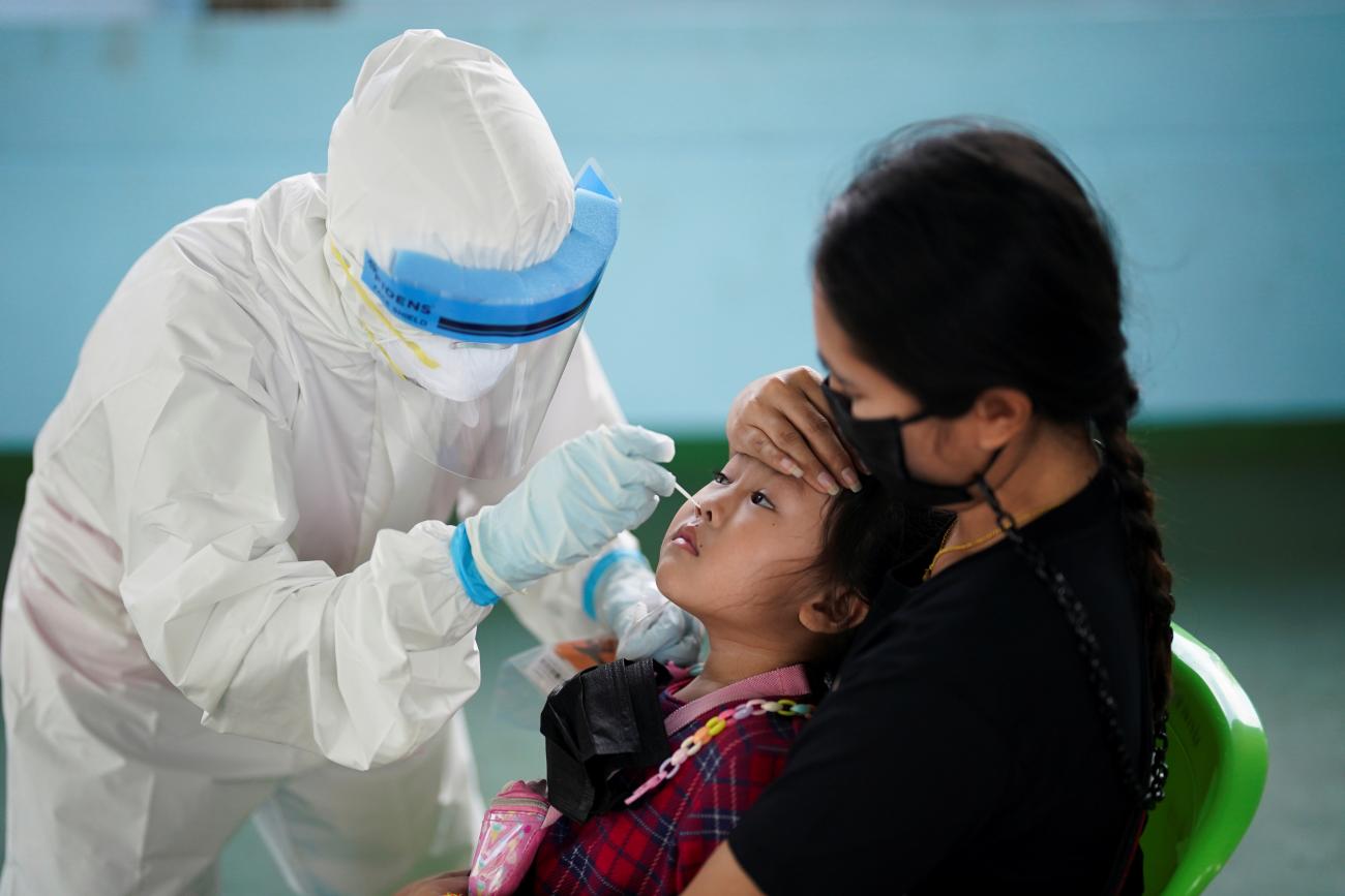 A healthcare worker takes a nasal swab sample from a child to test for COVID-19 in Bangkok, Thailand on April 16, 2021.